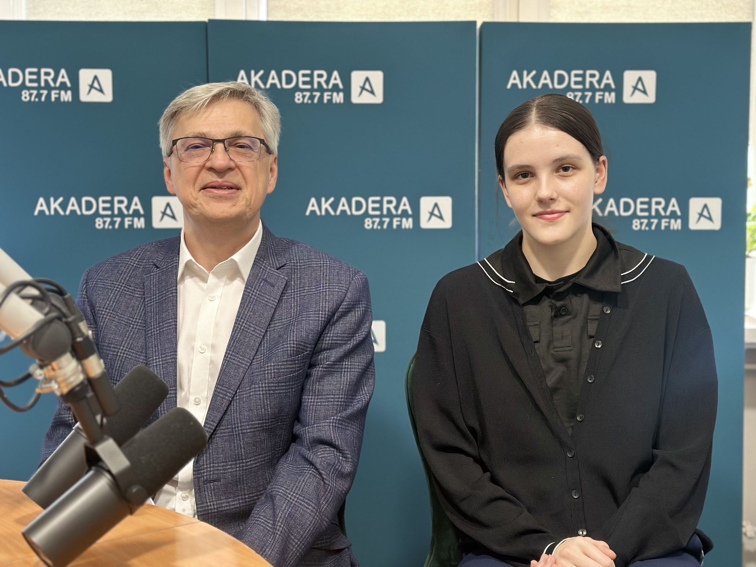 Julia Maksimowicz i prof. Bogusław Butryło siedzą razem w studiu Radia AKADERA podczas nagrania wywiadu. W tle widoczne logo AKADERA 87.7 FM.