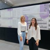 Na zdjęciu widzimy dwie studentki Wydziału Architektury Politechniki Białostockiej stojące przed planszą prezentującą ich projekt koncepcyjny zakładu produkcyjno-magazynowego z częścią biurową dla firmy PLUM. Wizualizacje, rysunki techniczne i układ funkcjonalny zaprezentowane na planszy świadczą o profesjonalnym podejściu i wysokim poziomie przygotowania projektu. Autorkami pracy są Dominika Dylewicz i Urszula Łukaszuk – laureatki konkursu ogłoszonego przez firmę PLUM.