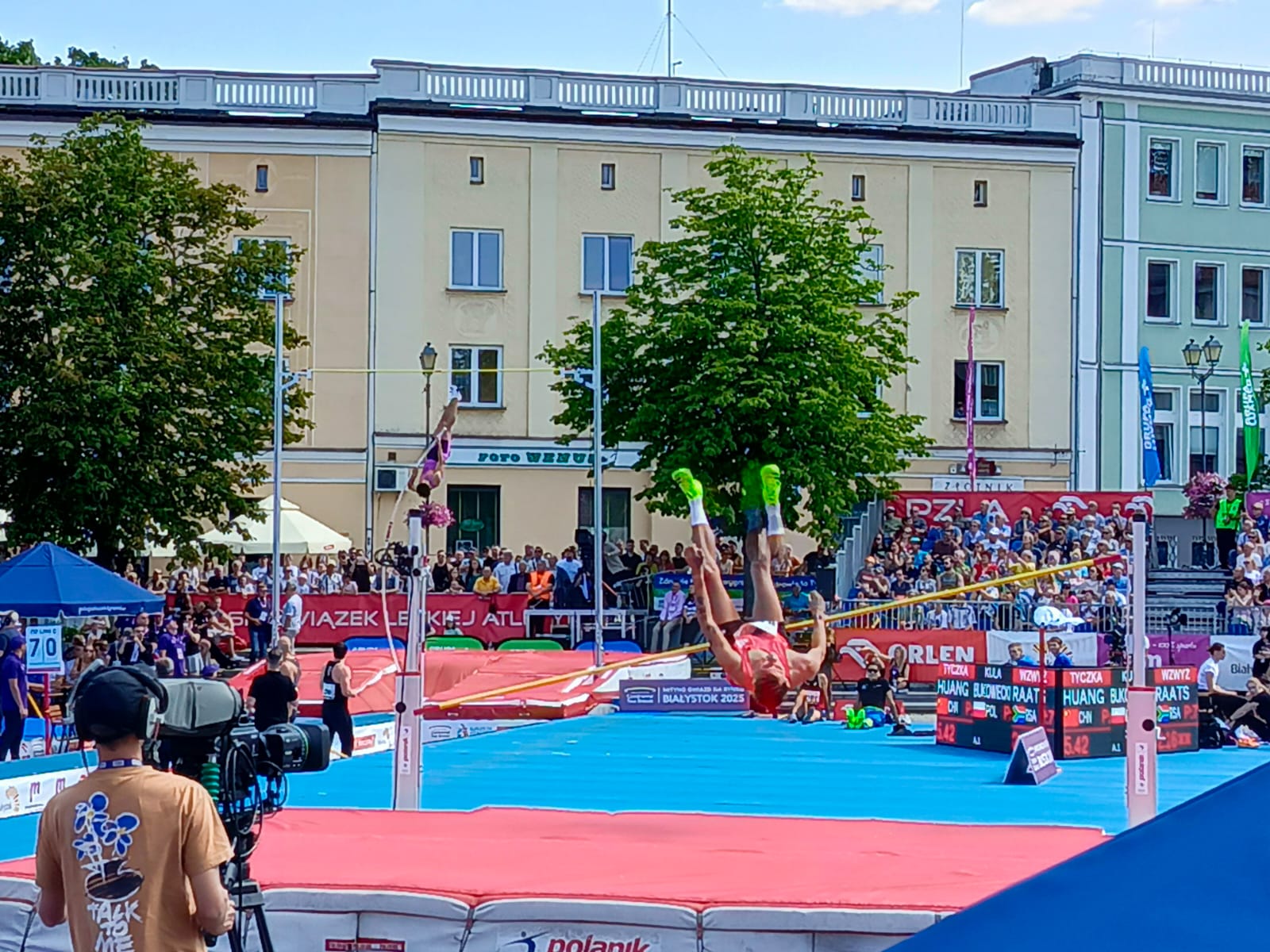 Zdjęcie doskonale oddaje atmosferę i emocje Mityngu Lekkoatletycznego 2025 w Białymstoku. Świetnie widać zaangażowanie zawodników, obecność mediów oraz dużą frekwencję kibiców.