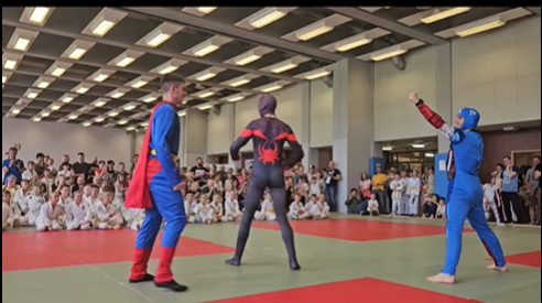 Osby przebrane za superbohaterów walcza w judo.