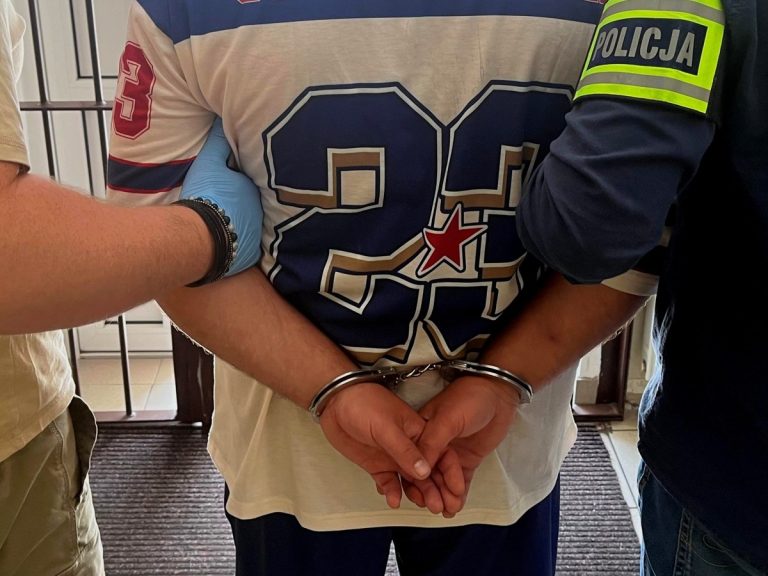 Mężczyzna w kajdankach trzymany przez funkcjonariuszy policji po zatrzymaniu w centrum Białegostoku za groźby karalne i zniszczenie mienia