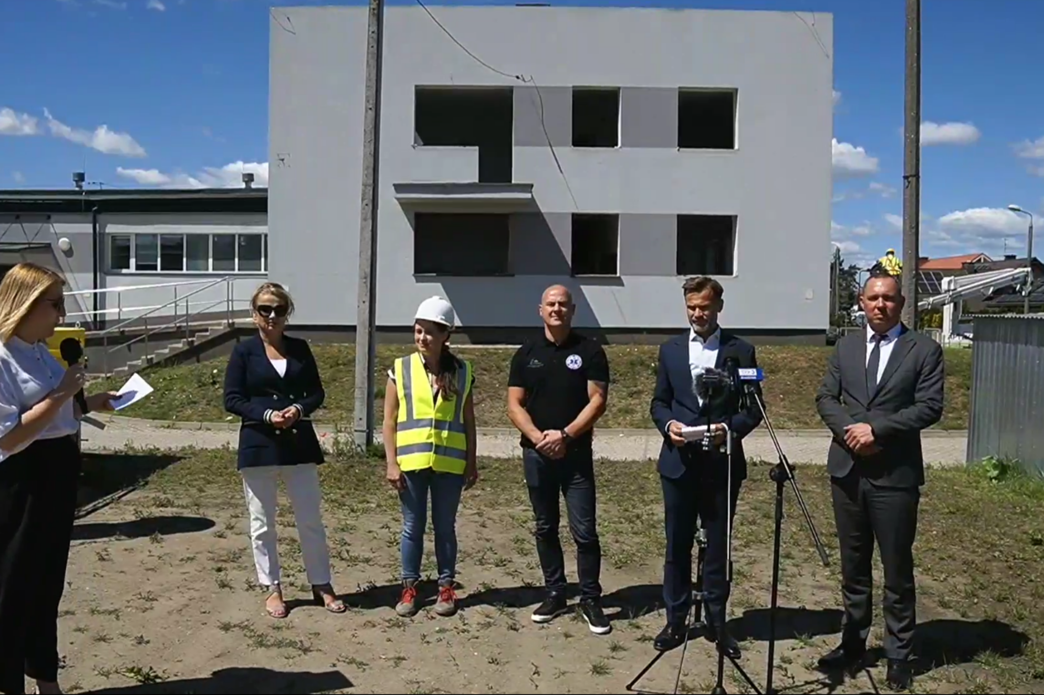 ludzie stoją na tle budowanej dyspozytorni