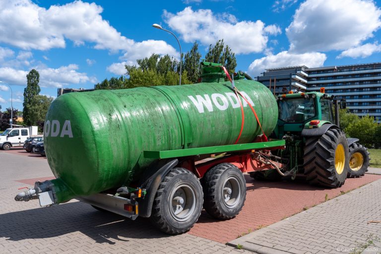 ciagnik rolniczy z cysterna z napisem woda