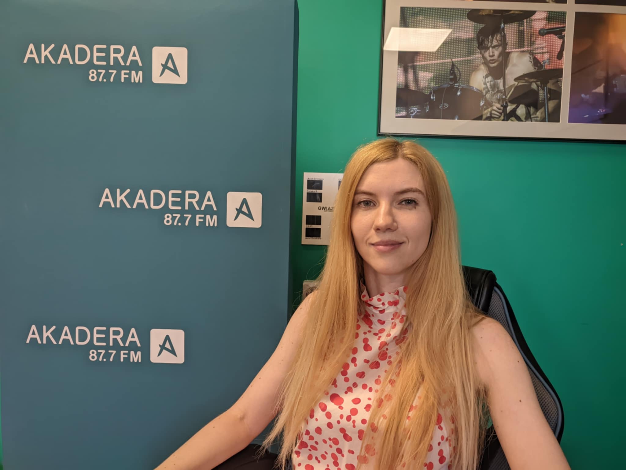 Kobieta pozuje do zdjęcia na ściance firmowej.