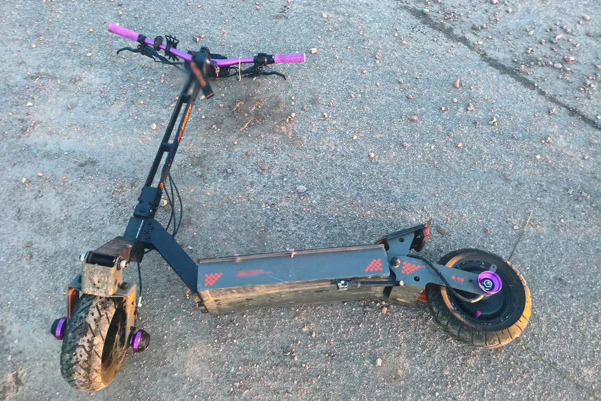 Uszkodzona hulajnoga elektryczna leżąca na jezdni po wypadku – ilustracja skutków brawury i braku kasku