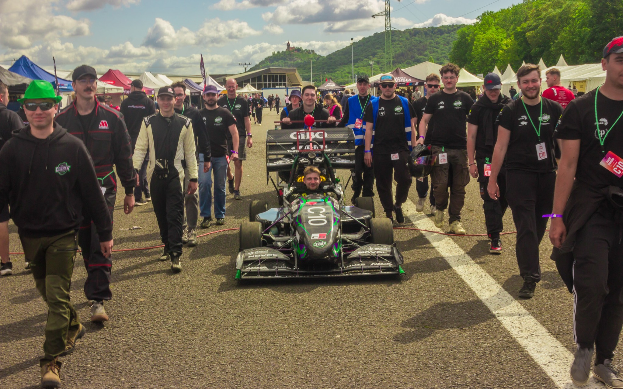 Mężczyźni idą obok bolidu.