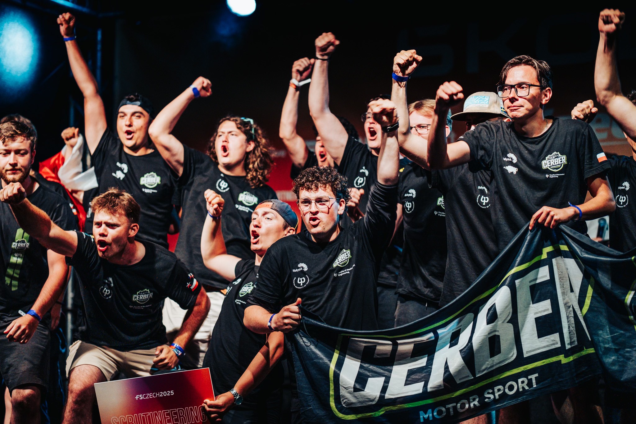 Ludzie stoją na scenie i się cieszą.