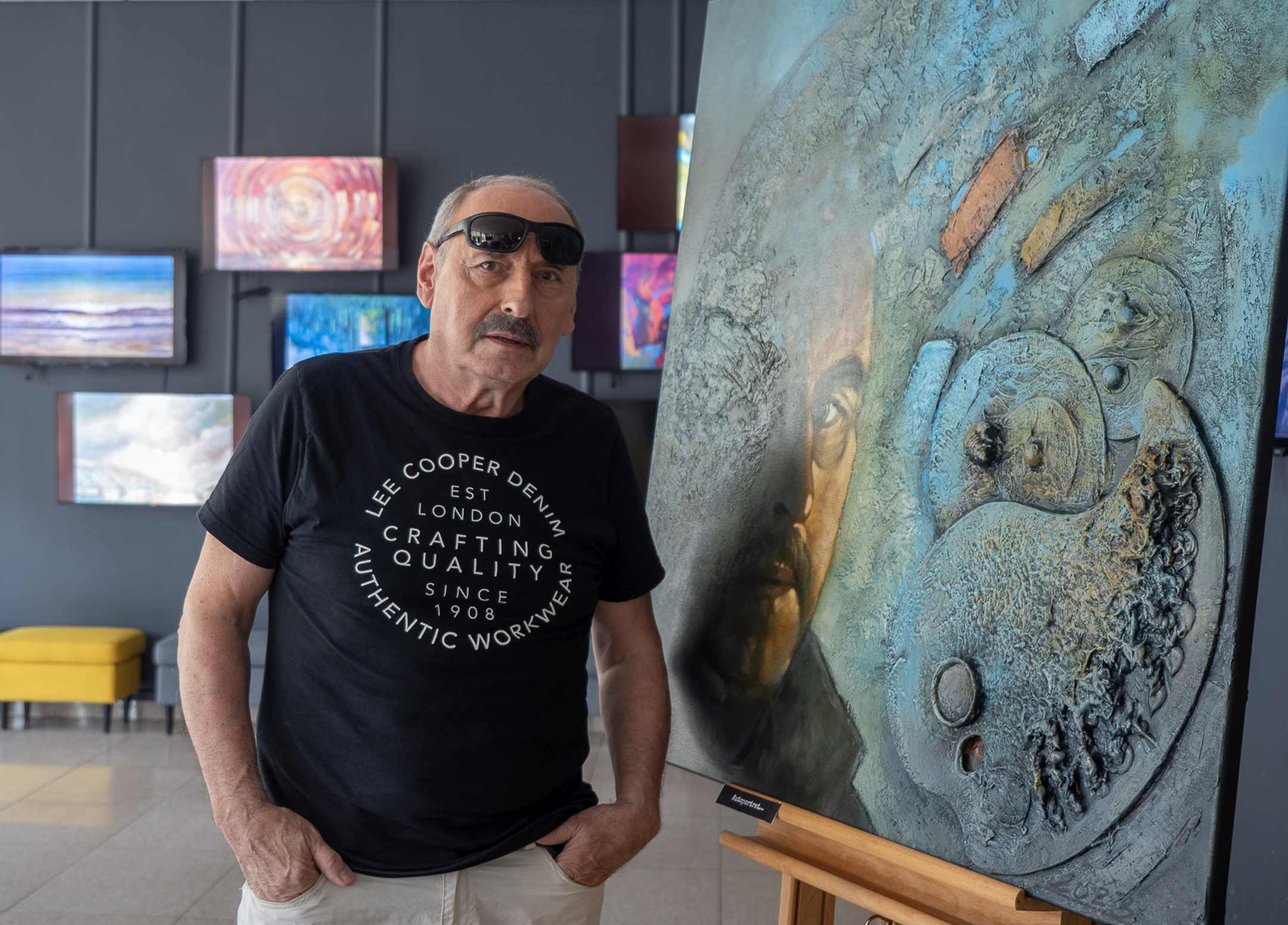 Mężczyzna stoi przy obrazie.