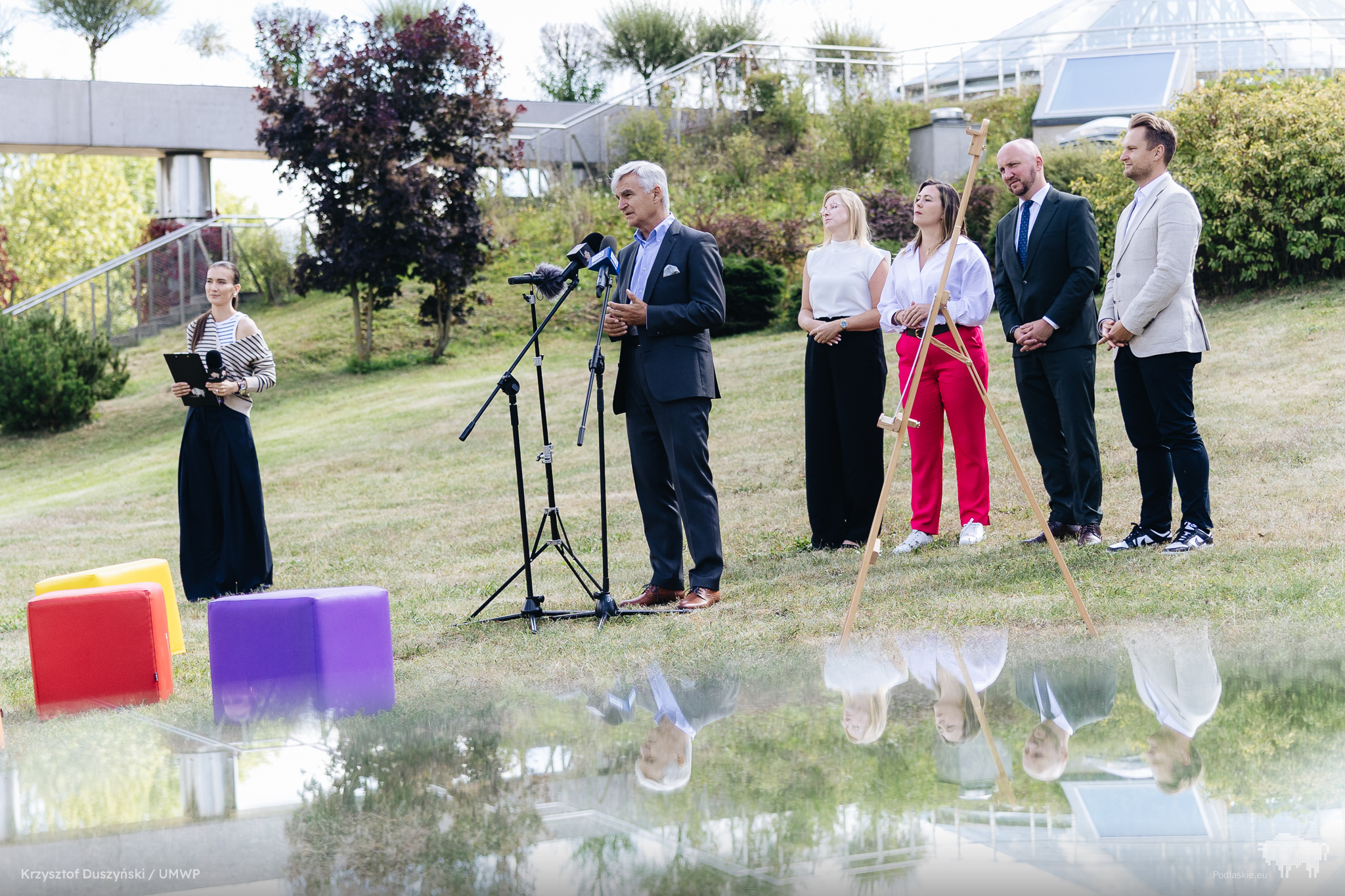 Ludzie stoją przed mikrofonem.