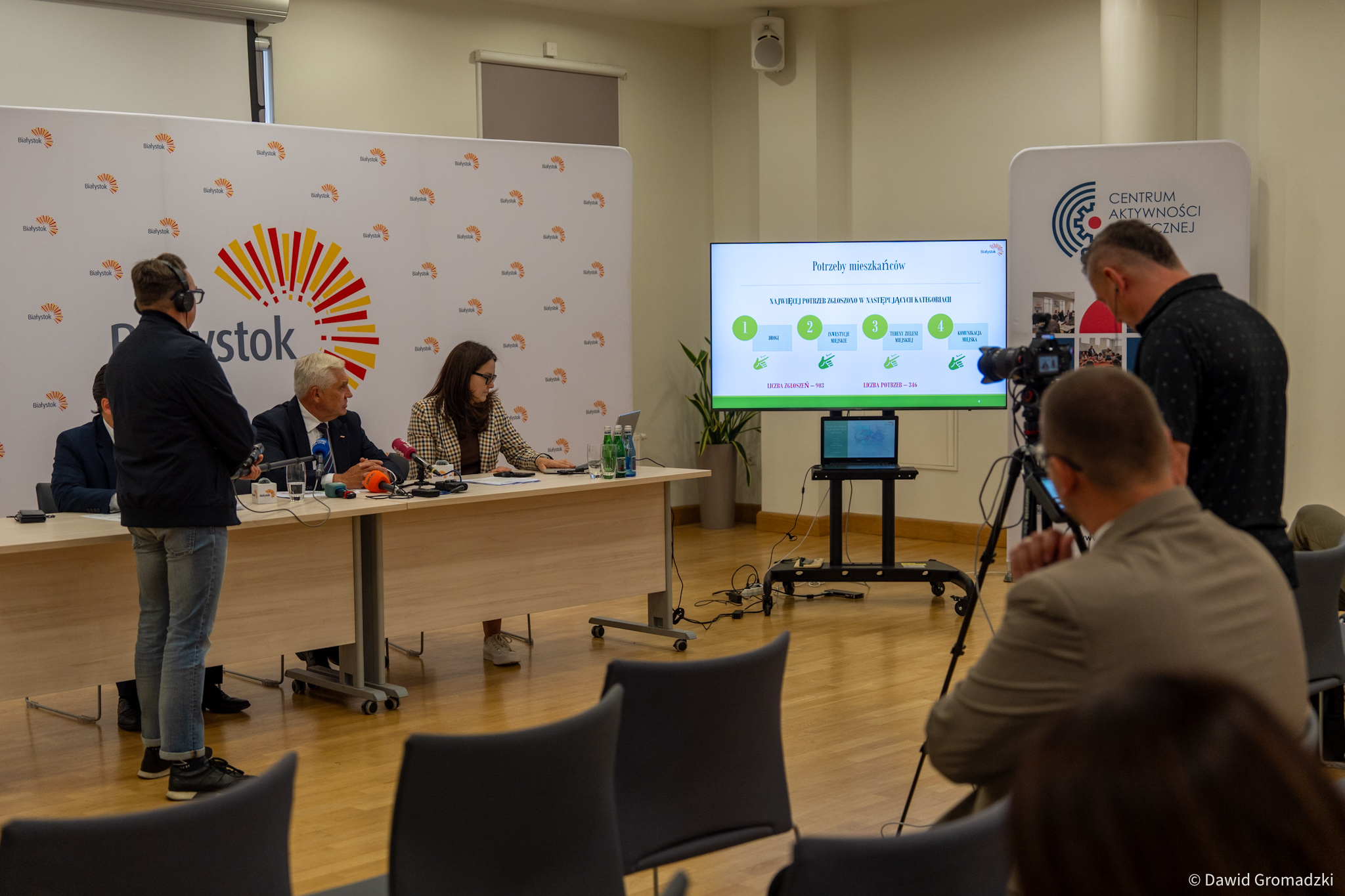 Konferencja prasowa przy stole.