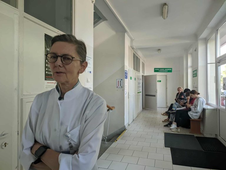 Lekarz na tle kolejki w szpitalu.
