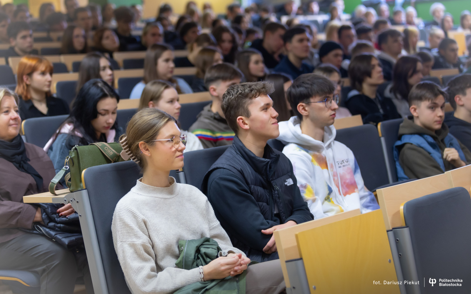 młodzież siedzi w auli i słucha wykładu