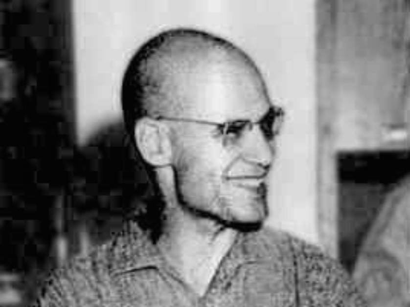 Czarno-biały portret Alexandra Grothendiecka przedstawiający go w średnim wieku, z łyso ogoloną głową i okularami, w swobodnej koszuli — matematyk w zamyśleniu nad abstrakcyjną teorią.