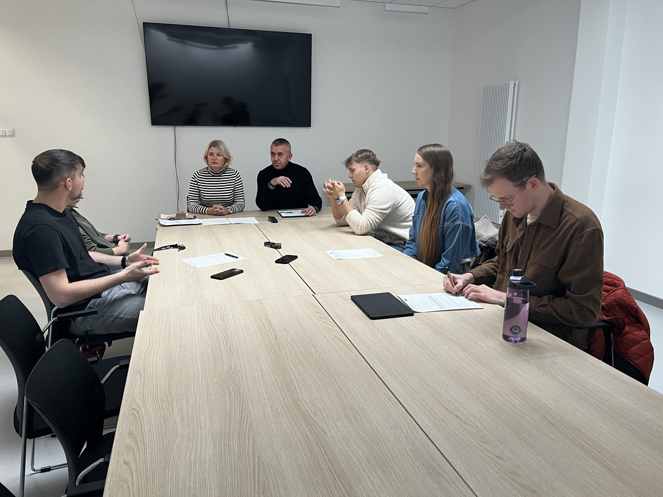 Naukowcy i studenci Politechniki Białostockiej rozmawiają przy stole konferencyjnym o doświadczeniach związanych z równością i różnorodnością.
