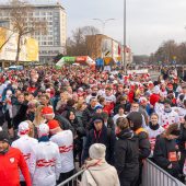 Tłum biegaczy w biało-czerwonych koszulkach i czapkach gromadzi się na starcie przy Alei Piłsudskiego w Białymstoku.