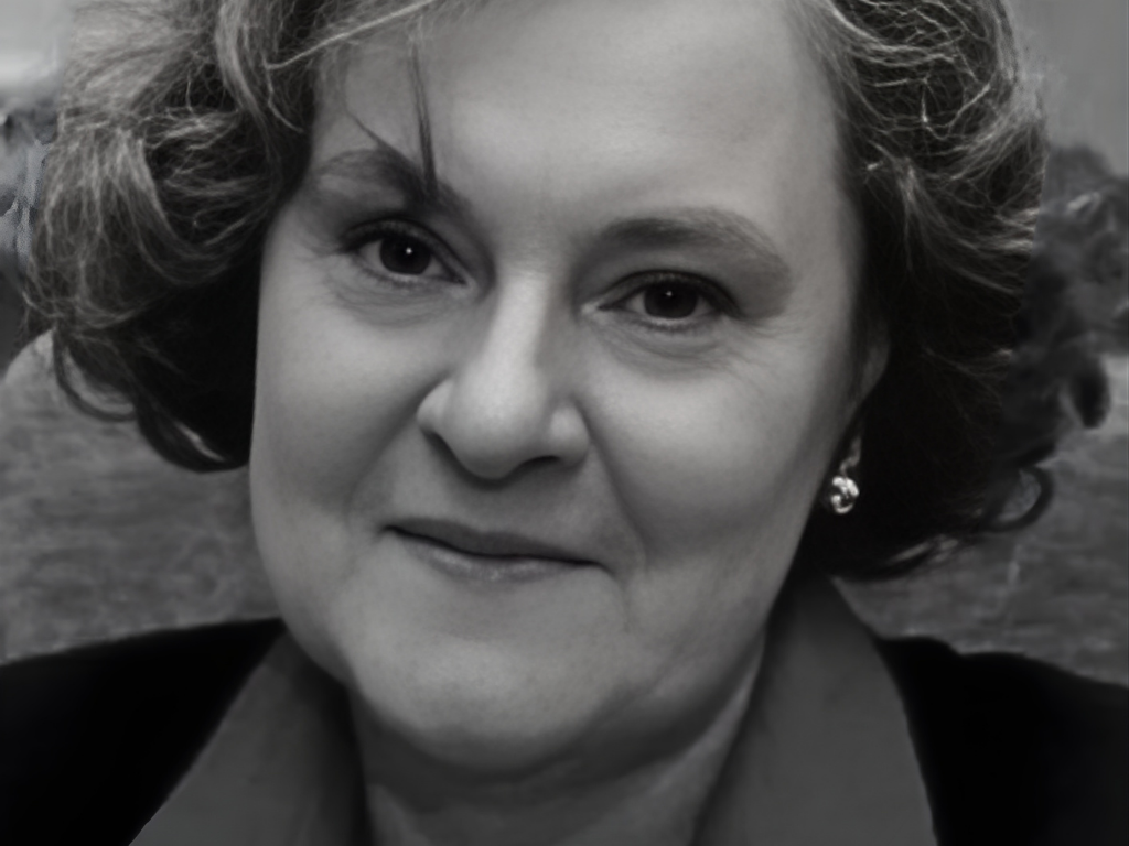 Czarno-biały portret prof. Anny Barbary Wydryckiej, kobiety o krótkich, falujących włosach, patrzącej w obiektyw z lekkim uśmiechem.