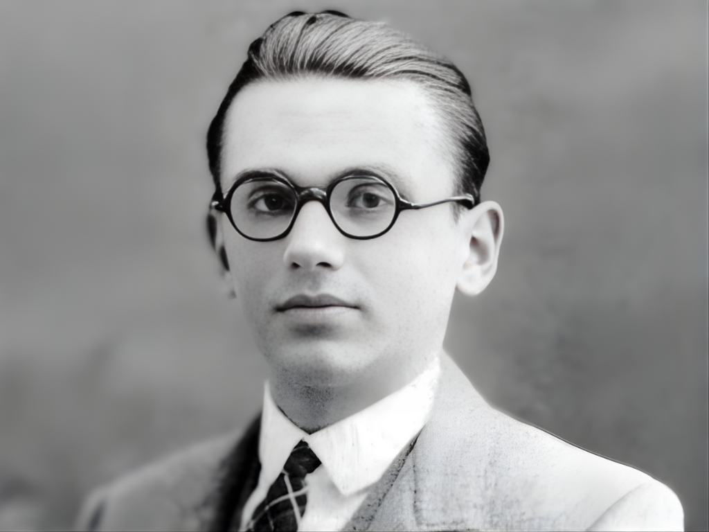 Czarno-biały portret młodego Kurta Gödla z lat 20., ubranego w garnitur i okrągłe okulary, patrzącego prosto w obiektyw.