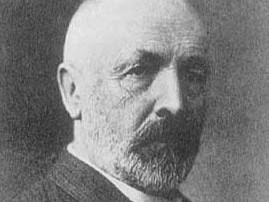 Portret Georga Cantora, starszy mężczyzna z wąsami i zarostem na brodzie, łysy.