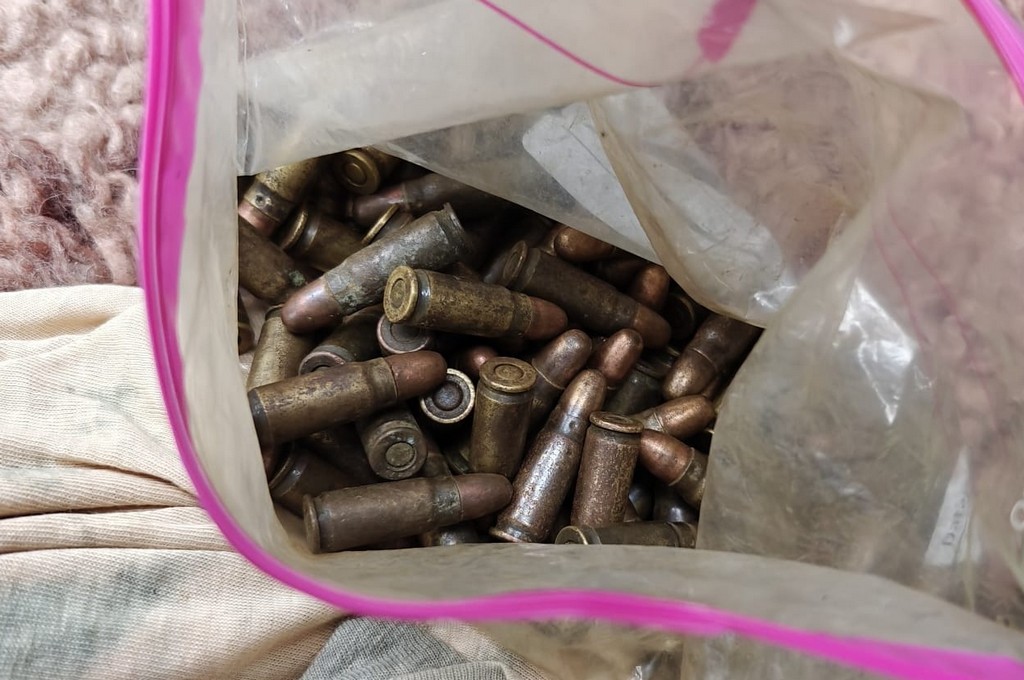 Zbliżenie na przezroczysty worek strunowy wypełniony starymi nabojami pistoletowymi zabezpieczonymi przez służby podczas interwencji na jarmarku staroci w Kiermusach.
