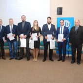 Grupowe zdjęcie laureatów konkursu SEP oraz przedstawicieli kapituły i organizatorów podczas uroczystości wręczenia nagród na Politechnice Białostockiej, uczestnicy stoją na scenie i trzymają dyplomy oraz nagrody.