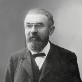 Czarno-biały portret Henriego Poincarégo w formalnym stroju, z brodą i okularami pince-nez, fotografia z 1913 roku, wykonana przed 1923 rokiem.