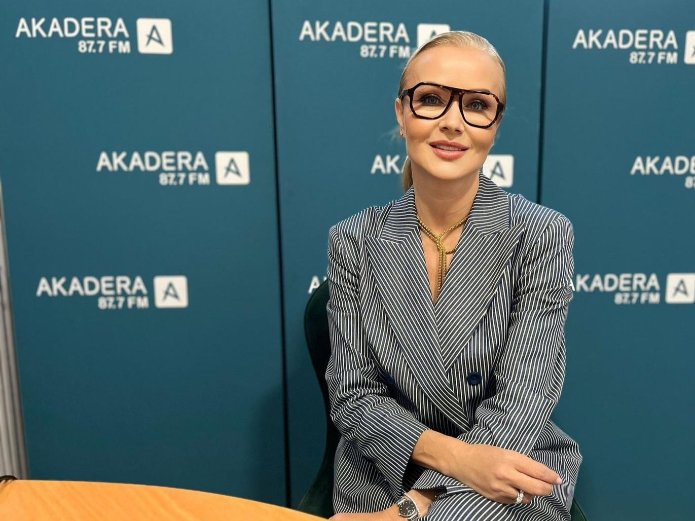 Dr Magdalena Borkowska podczas rozmowy w studiu Radia AKADERA, siedząca przy stole na tle ścian z logo AKADERA 87,7 FM.