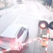 Samochód osobowy marki BMW wjeżdża na przejazd kolejowy w Hajnówce mimo włączonych sygnałów świetlnych i opuszczonych zapór, kadr z monitoringu.